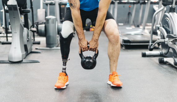 Image of a male with a prosthetic leg working out in the gym 