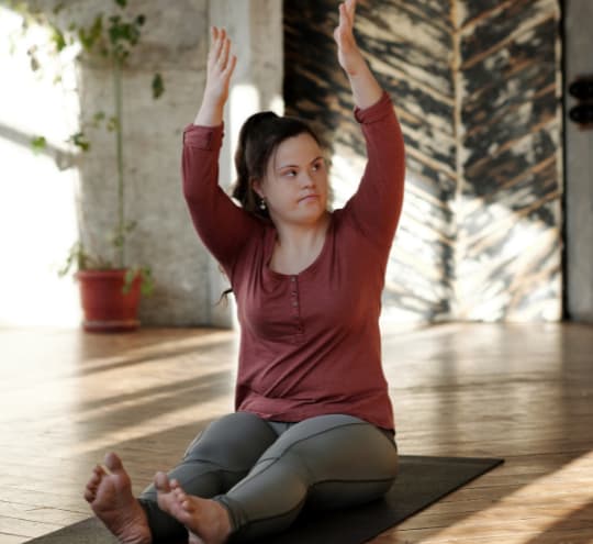 Woman with down syndrome stretching on a yoga mat